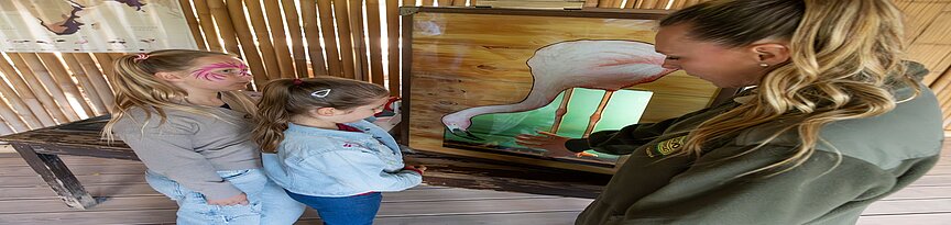 Lotsin mit zwei Kindern an Lernstation zu Chileflamingos