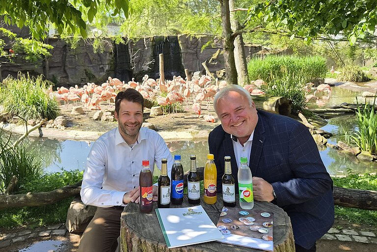 Brauereichef Kamann und Zoodirektor Junhold vor Flamingos