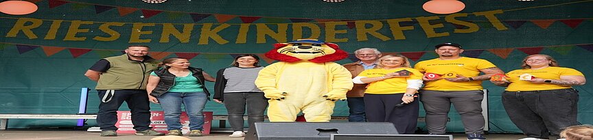 Scheckübergabe mit Mitarbeitern von Zoo, DHL und Uniklinik sowie DHL Maskottchen
